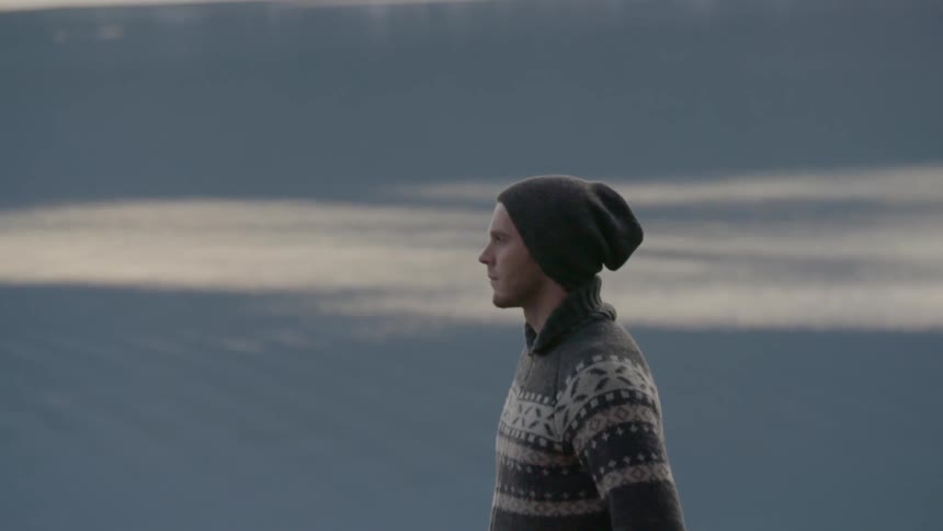 A man in a beanie looks around