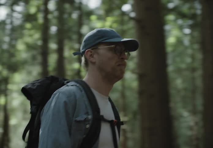A man and a woman hiking with trees in the background