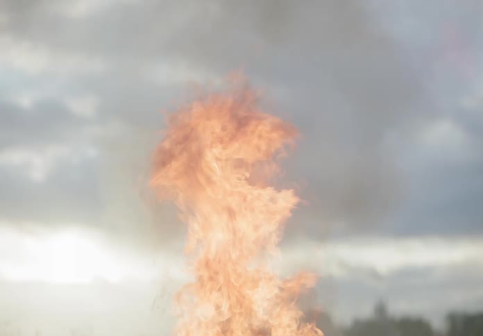 A bottle is thrown into the bonfire making it explode