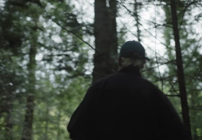 A man jogs alone through a forest