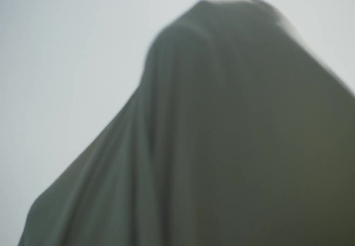 A person covered in a gray sheet