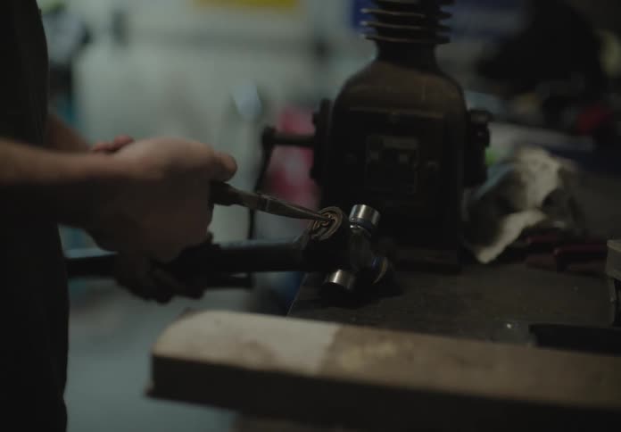 A man using pliers to remove a part from a metal object
