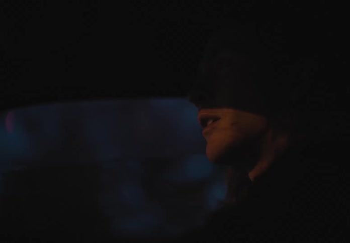 A man is driving in a car at night