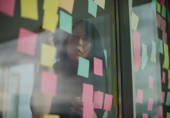 A woman is thinking and writing notes