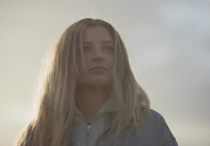 A teenager stands outside and looks around