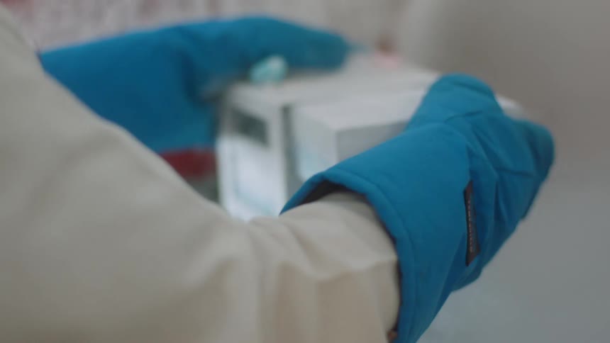 Laboratory technician places samples in freezing chamber