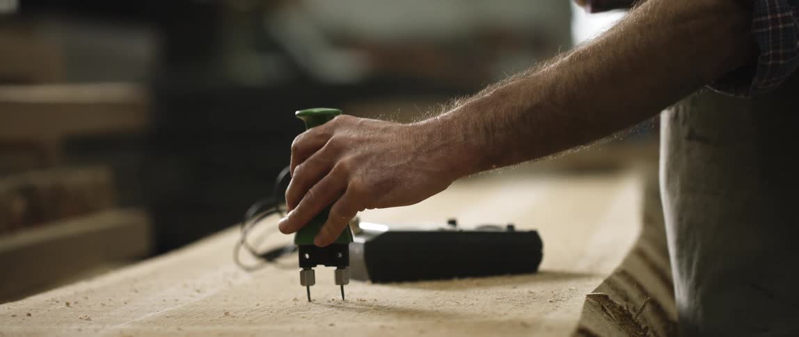 A man is using a mallet to hit an object