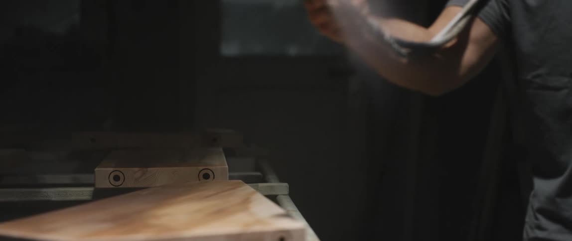 A white male sprays a mist on a piece of wood