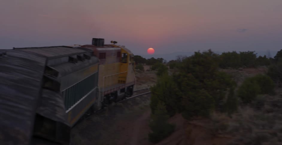 A train traveling on rail with the sky in the background