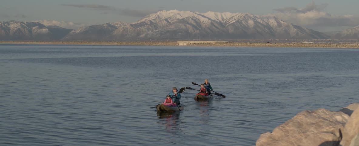 A family of four paddles two canoes across a lake