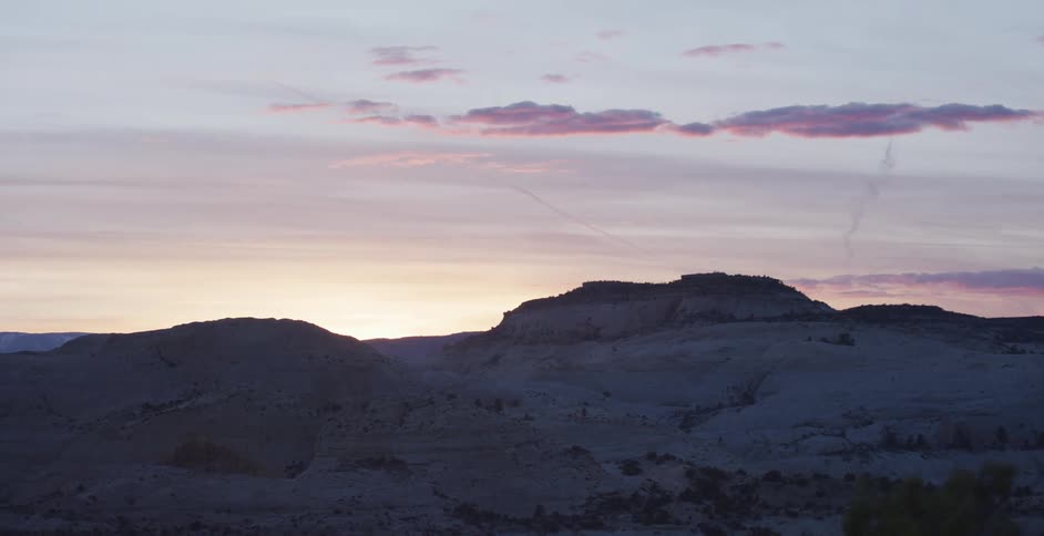 The sun rises behind a mountain