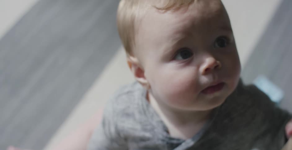 A baby boy sits on the floor and plays