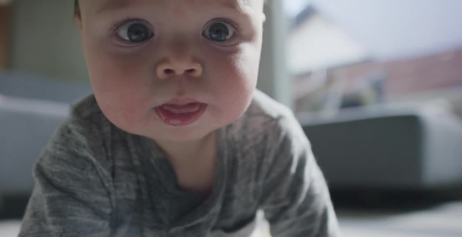 Baby crawls and tries to reach the camera in the living room