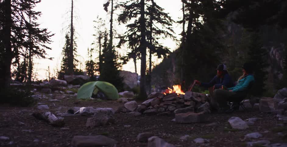 A small fire at a campsite at low sun