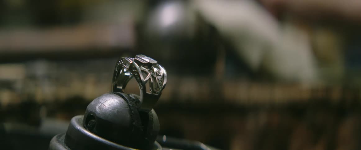 A man places a gem in a ring