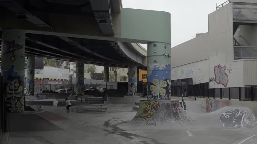 Person skateboarding through skate park with energetic urban youth vibe