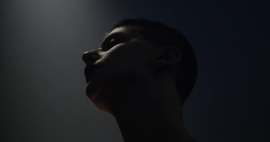 A white female dancer slowly moves her head downward