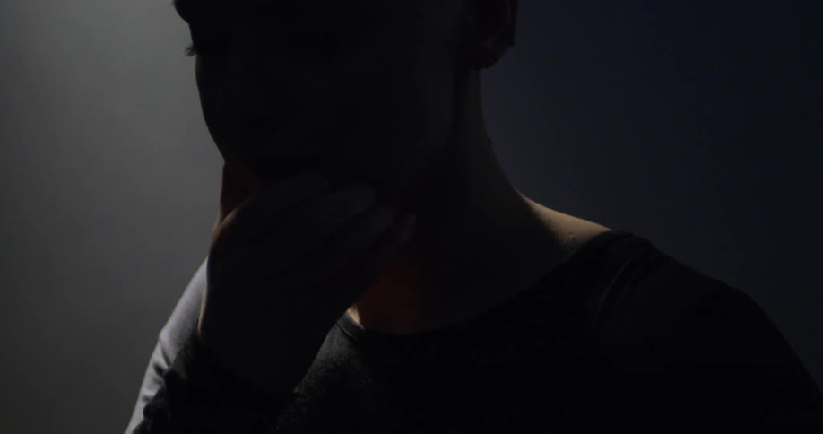 The silhouette moves in the darkness