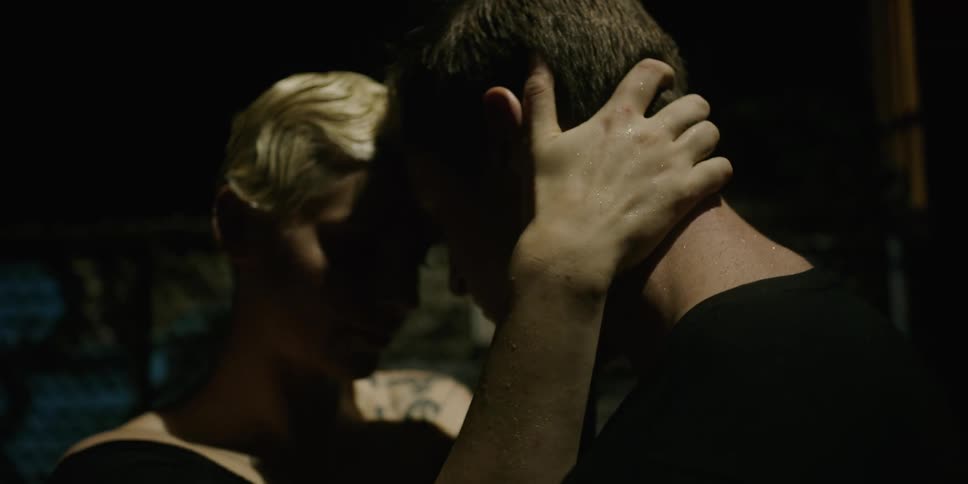 A boyfriend and girlfriend embrace and slow dance outside at night