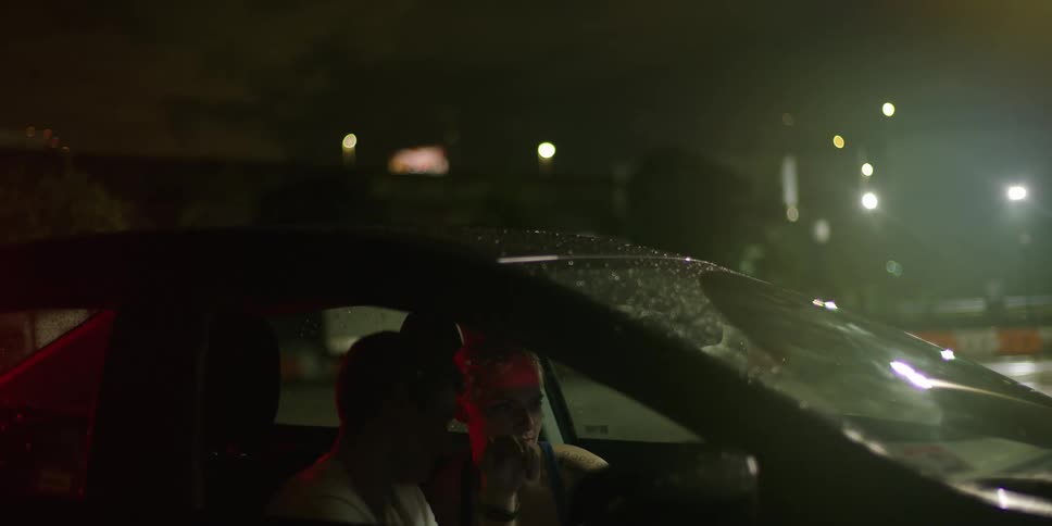 A man and a woman sitting in a car talking