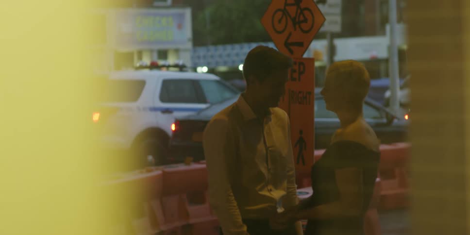 A couple stand outside a building and talk