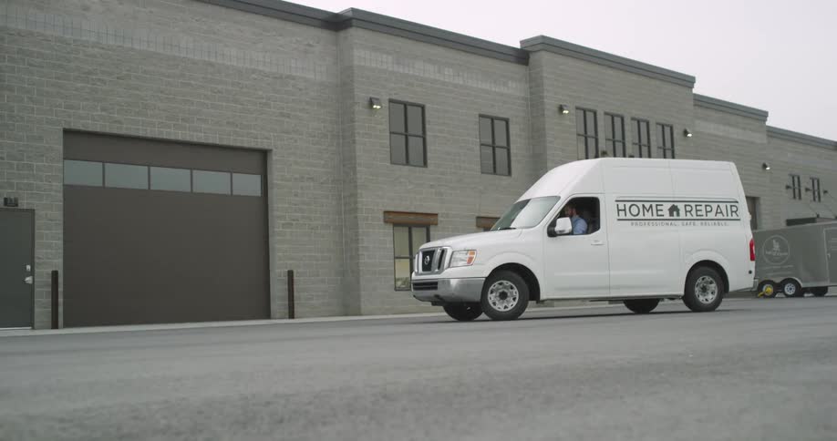 A white van pulls away from a business
