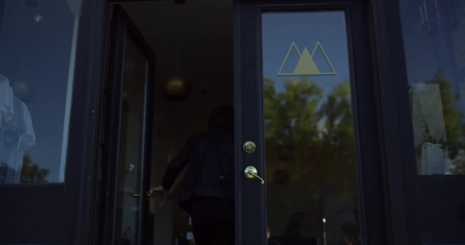 A woman is walking into a store
