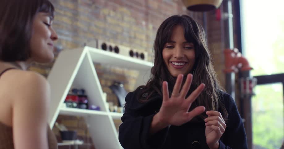 A woman is in a store trying on rings