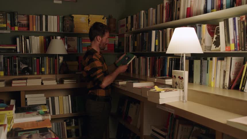 A man is looking at books in a library