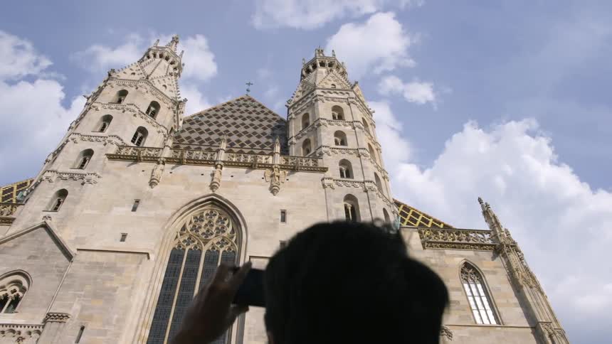 A man is talking pictures of a building outdoors