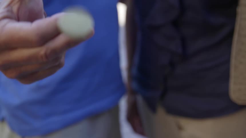 Close up of hand flipping brass coin