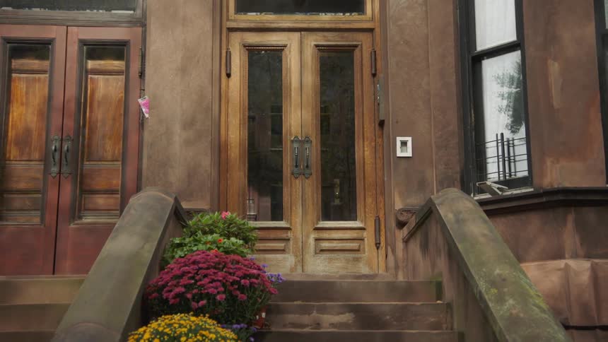 Mums sit on the stone stairs of a building with wood doors