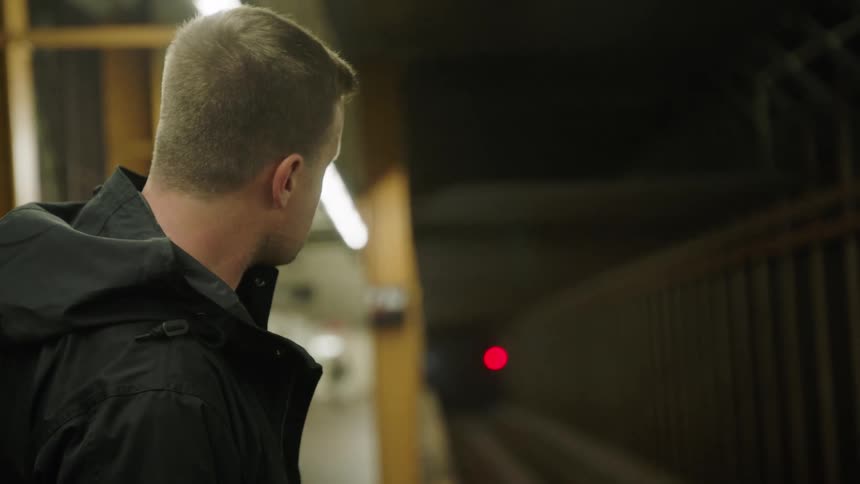 The man walks toward the tracks