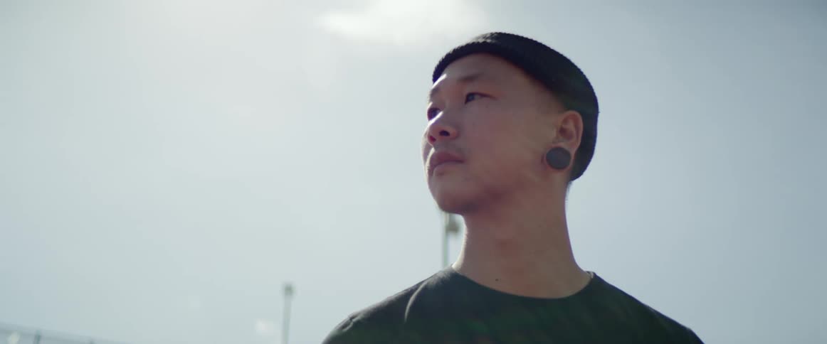 Young man wearing beanie stands outdoors at day