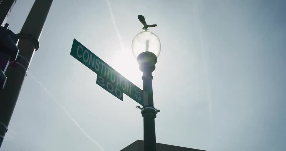 A street lamp with a street sign attached to it