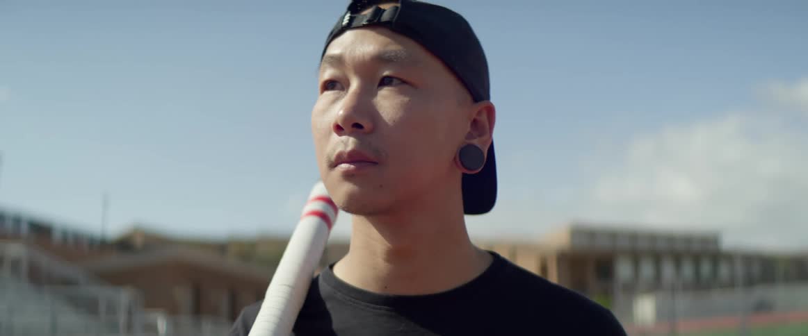A man stands with a pole on his shoulder