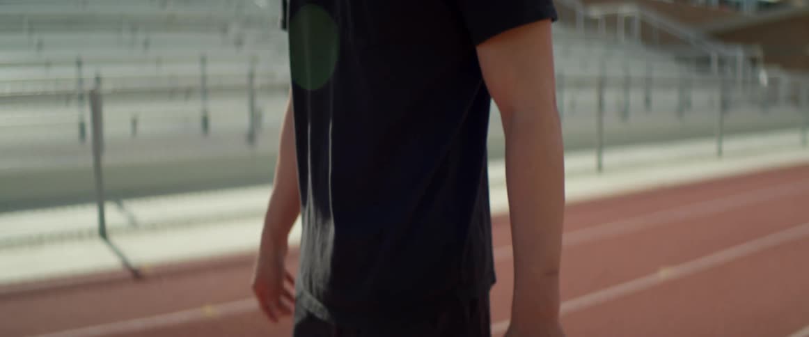 A man is walking on the track stretching