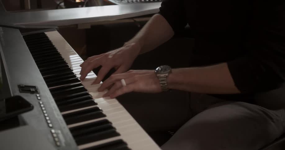A man in a studio playing a keyboard