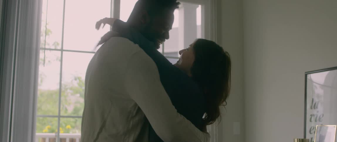 Couple hug and kiss in living room