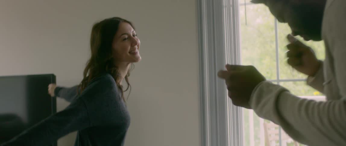 A man and woman dance in their home