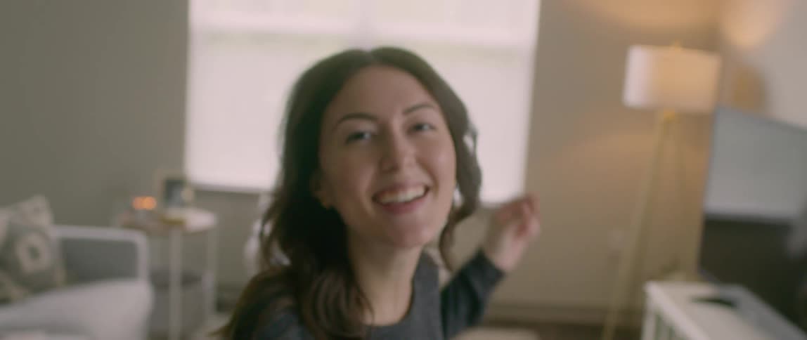 Happy woman laughing and dancing indoors in celebration
