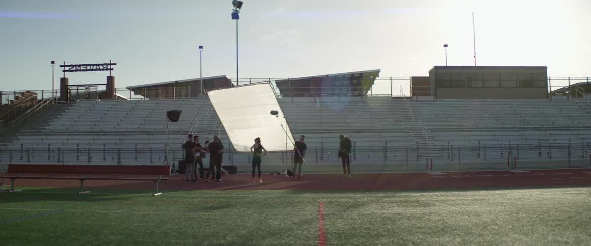 A group of teenagers at a track are making a film