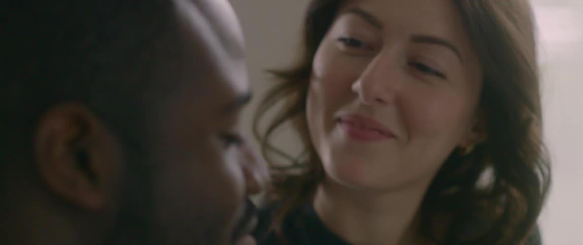 Close up of a man and a woman talking very close together in a room