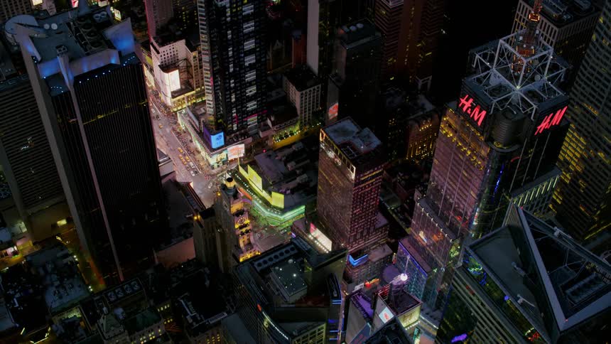 The vehicles drive down the avenue in the city at night