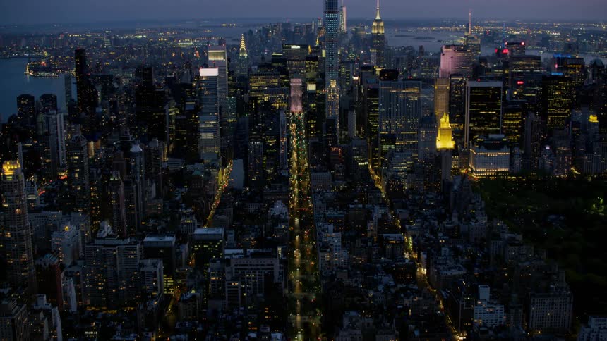 The skyscrapers in a downtown area are illuminated at night