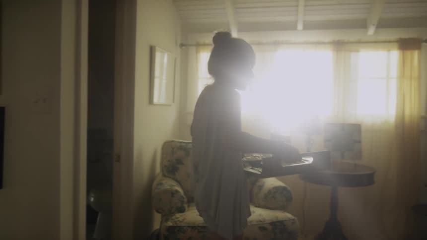 A girl carrying a breakfast tray towards a bed