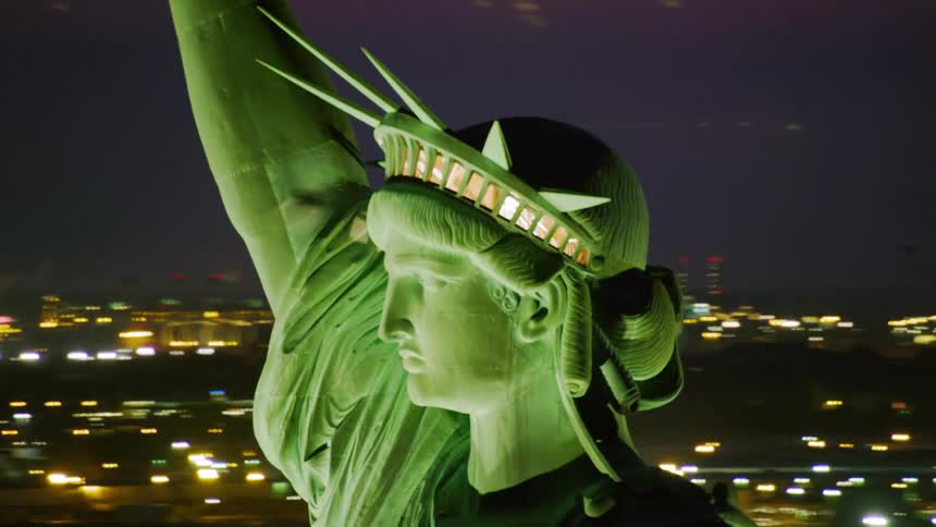 The statue of liberty is brightly lit at night