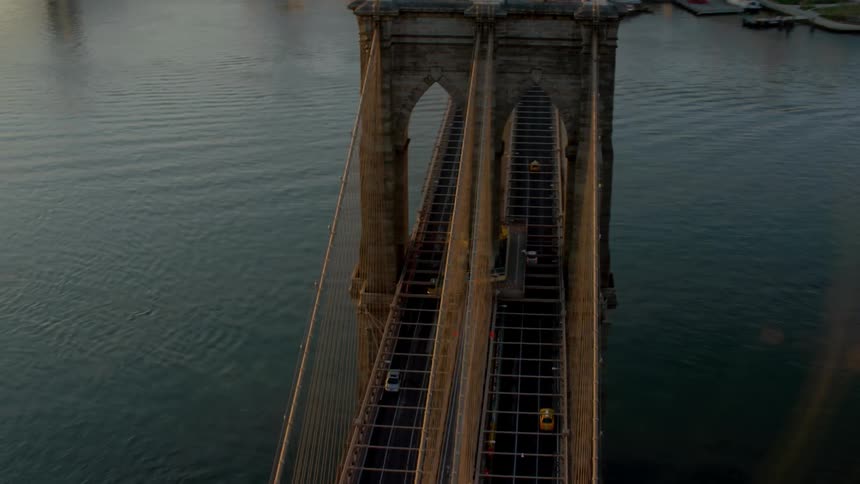 Cars move across a suspension bridge over a river