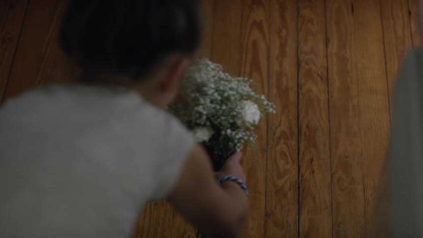 A girl gathering flowers into a bunch and picking them up