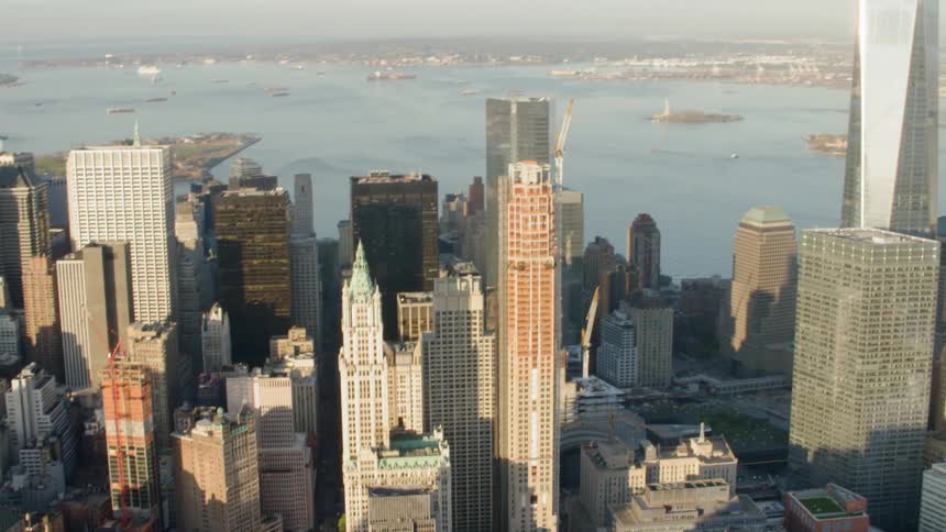 A tall skyscraper towers over the other buildings in a downtown area
